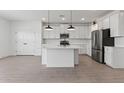 Bright kitchen featuring white cabinets, stainless appliances, a kitchen island, and an open floor plan at 7416 S 76Th Ln, Laveen, AZ 85339