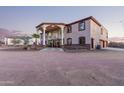 Two-story house with stucco exterior, large windows, and a porte-cochere, plus a three car garage at 8315 E Palm Ln, Mesa, AZ 85207