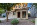 Two-story house with tan exterior, landscaped yard, and two-car garage at 1174 E Canyon Creek Dr, Gilbert, AZ 85295