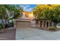 Two-story house with tan exterior, landscaped yard, and two-car garage at 1174 E Canyon Creek Dr, Gilbert, AZ 85295