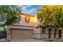 Two-story house with tan exterior, landscaped yard, and two-car garage at 1174 E Canyon Creek Dr, Gilbert, AZ 85295