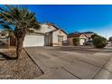 House with a driveway, palm tree, and neighboring homes at 12810 W Edgemont Ave, Avondale, AZ 85392