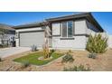 Single-story home with gray exterior, two-car garage, and landscaped front yard at 17852 W Country Club Ter, Surprise, AZ 85387