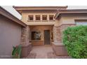 Elegant home entry with brick detailing and a charming covered porch at 2740 S Honeysuckle Ln, Gilbert, AZ 85295