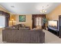 Bright living room with sectional sofa, large TV, and neutral color scheme at 2910 E Quiet Hollow Ln, Phoenix, AZ 85024