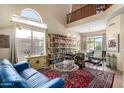 Living area featuring a blue couch, large bookcase and glass coffee table at 3055 N Red Mountain Rd # 149, Mesa, AZ 85207