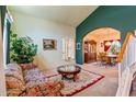 Living room features floral couch, coffee table, and view into dining area at 6751 N 77Th Dr, Glendale, AZ 85303