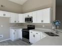 Modern kitchen with white cabinets, stainless steel appliances, and quartz countertops at 7045 W Ocotillo Rd, Glendale, AZ 85303