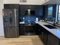 Stainless steel appliances and dark cabinetry highlight this updated kitchen at 7904 E Pepper Tree Ln, Scottsdale, AZ 85250