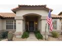 Inviting front entryway with an arched walkway and American flag at 831 E Spanish Moss Ln, Phoenix, AZ 85022