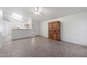 Open-concept living area with tile floors, ceiling fan, and view of kitchen beyond half wall at 8549 E Carol Ave, Mesa, AZ 85208