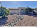 Front yard with gravel landscaping and mature trees at 9283 W Rafael Dr, Arizona City, AZ 85123