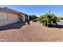 Side view of the house with rock landscaping at 9283 W Rafael Dr, Arizona City, AZ 85123