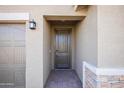 Front entry with a dark wood door and stone accent wall at 19959 W Rancho Dr, Litchfield Park, AZ 85340