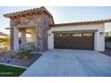 Single-story home with stone accents and a two-car garage at 20487 W Minnezona Ave, Buckeye, AZ 85396