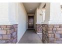 Front entry with dark brown door and stone accents at 8209 W Lane Ave, Glendale, AZ 85303