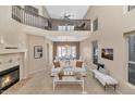 Bright living room boasts a fireplace, soaring ceilings, and an open concept layout to the dining room at 9452 S 51St St, Phoenix, AZ 85044