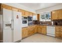 Bright kitchen with wood cabinets, tile floor, and modern appliances at 10288 W Snead N Cir, Sun City, AZ 85351