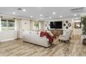 Bright and airy living room features hardwood floors and a large flat-screen TV at 19320 W Melvin St, Buckeye, AZ 85326