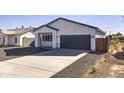 Modern craftsman style home with a dark garage door and wood fence at 205 E Jackson Ave, Buckeye, AZ 85326