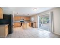 Kitchen with light wood cabinets, an island, and black appliances at 30788 N Whirlaway Trl, San Tan Valley, AZ 85143