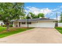 Single-story home with a basketball hoop, white garage doors, and a well-maintained lawn at 4525 E Calle Ventura --, Phoenix, AZ 85018