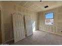 Unfinished bedroom with two doors and a window providing natural light at 47748 W Kenner Dr, Maricopa, AZ 85139