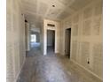 Unfinished hallway showing the layout with multiple doorways and a view towards the backyard at 47748 W Kenner Dr, Maricopa, AZ 85139