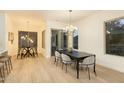 Bright dining room with contemporary chandelier, light wood floors, and a sliding glass door to the exterior at 6137 E Roland St, Mesa, AZ 85215