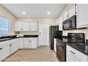 Modern kitchen featuring white cabinets and black countertops at 710 S Monterey St, Gilbert, AZ 85233