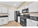 Modern kitchen with white cabinets, black appliances, and granite counters at 710 S Monterey St, Gilbert, AZ 85233