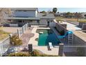 Inviting swimming pool with a slide and diving board in a fenced backyard at 7528 N 185Th Ave, Waddell, AZ 85355