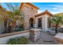 Front entry with stonework, palm trees, and a fountain at 20621 N Canyon Whisper Dr, Surprise, AZ 85387