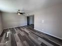 Open living room showcasing gray wood floors, a ceiling fan, and neutral color scheme at 2629 W Ocotillo Rd # 3, Phoenix, AZ 85017