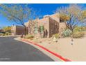 Side view of a two-story home with a two-car garage, showing desert landscaping at 36601 N Mule Train Rd # B19, Carefree, AZ 85377