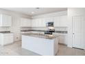 Modern kitchen with white cabinets, granite countertops, and island at 4930 S 105Th Ln, Tolleson, AZ 85353
