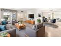 Bright living room with comfy sofas, mid-century modern coffee table, and large windows at 9946 W Palmeras Dr, Sun City, AZ 85373