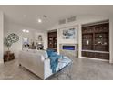 Spacious living room with a fireplace, built-in shelving, and large windows at 10031 N Palisades Blvd, Fountain Hills, AZ 85268