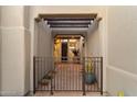 Inviting entryway with a metal gate and pathway leading to a wood front door at 11060 E Mark Ln, Scottsdale, AZ 85262