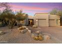 Tan stucco home with a two-car garage and drought-tolerant landscaping, creating a low-maintenance exterior at 11060 E Mark Ln, Scottsdale, AZ 85262