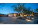 Night view of a two-story home with a two-car garage and well-lit landscaping at 12824 E Jenan Dr, Scottsdale, AZ 85259