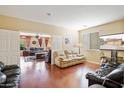 Open concept living room with hardwood floors and views into another living area at 15296 W Coolidge St, Goodyear, AZ 85395