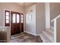 Entryway with tiled floors, a wooden door, and a carpeted staircase at 16636 S 34Th Way, Phoenix, AZ 85048