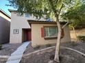 Tan two-story house with red door, tree, and walkway at 1727 W Pollack St, Phoenix, AZ 85041