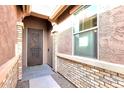 Front entry with a security door and brick accents at 18404 W Long Lake Rd, Goodyear, AZ 85338