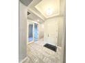 Bright foyer featuring gray tile flooring, neutral paint, and a tray ceiling with recessed lighting at 18404 W Long Lake Rd, Goodyear, AZ 85338