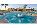 Resort-style pool and spa with a large clubhouse in the background at 21295 N 262Nd Dr, Buckeye, AZ 85396