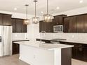 This gourmet kitchen features a large island, stainless steel appliances, and dark wood cabinetry at 22541 W Pontiac Dr, Surprise, AZ 85387