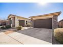 Two-car garage with brown doors and stone exterior at 22917 E Camina Buena Vis, Queen Creek, AZ 85142