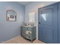 Entryway with light blue walls, antique dresser, and mirror at 31063 W Cheery Lynn Rd, Buckeye, AZ 85396